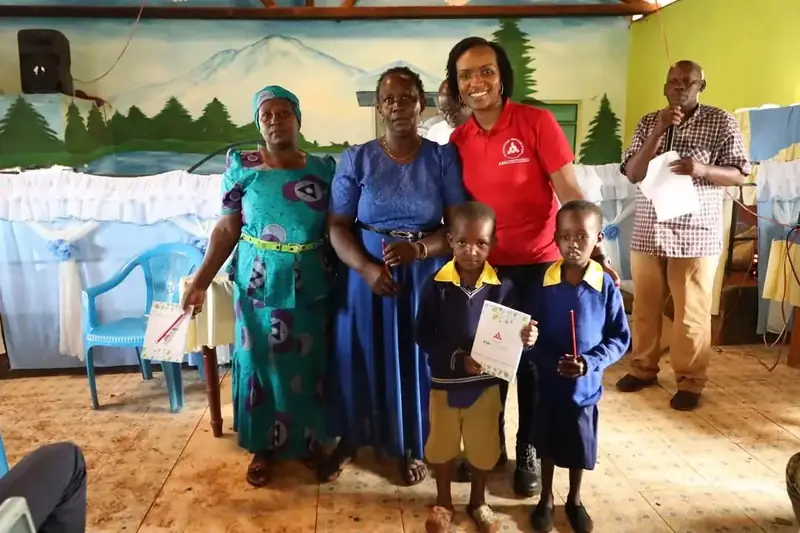 Pupils and parents receive certificates during the Grow A Classroom visit to Iiani School