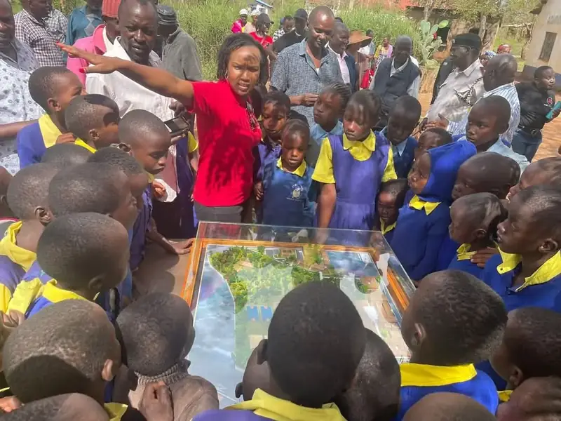 Pupils gather around the school masterplan model at Iiani School, Nzambani