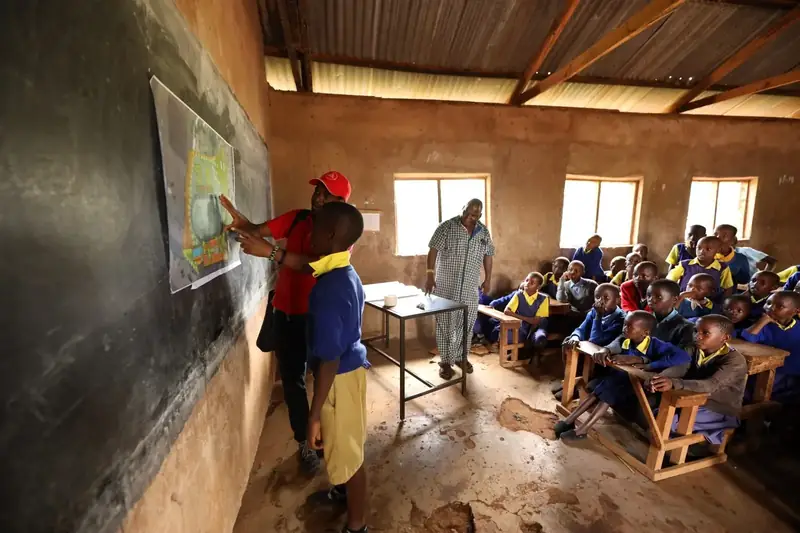 AAK architect explains the school masterplan to pupils in a classroom at Iiani School