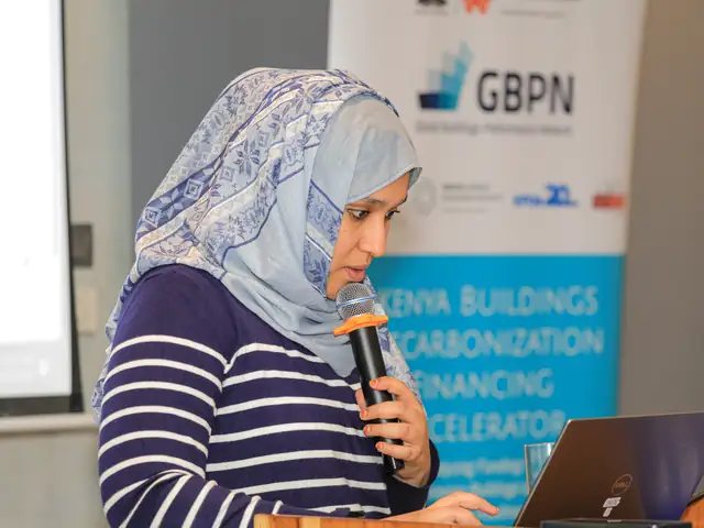A speaker presents in front of the GBPN banner